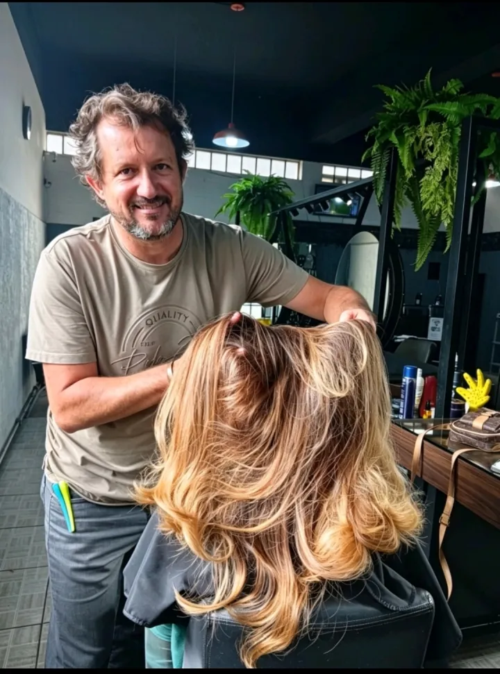Sidnei S. Danttas segurando e avaliando o loiro platinado recém-feito numa cliente, no salão Estética Hair7